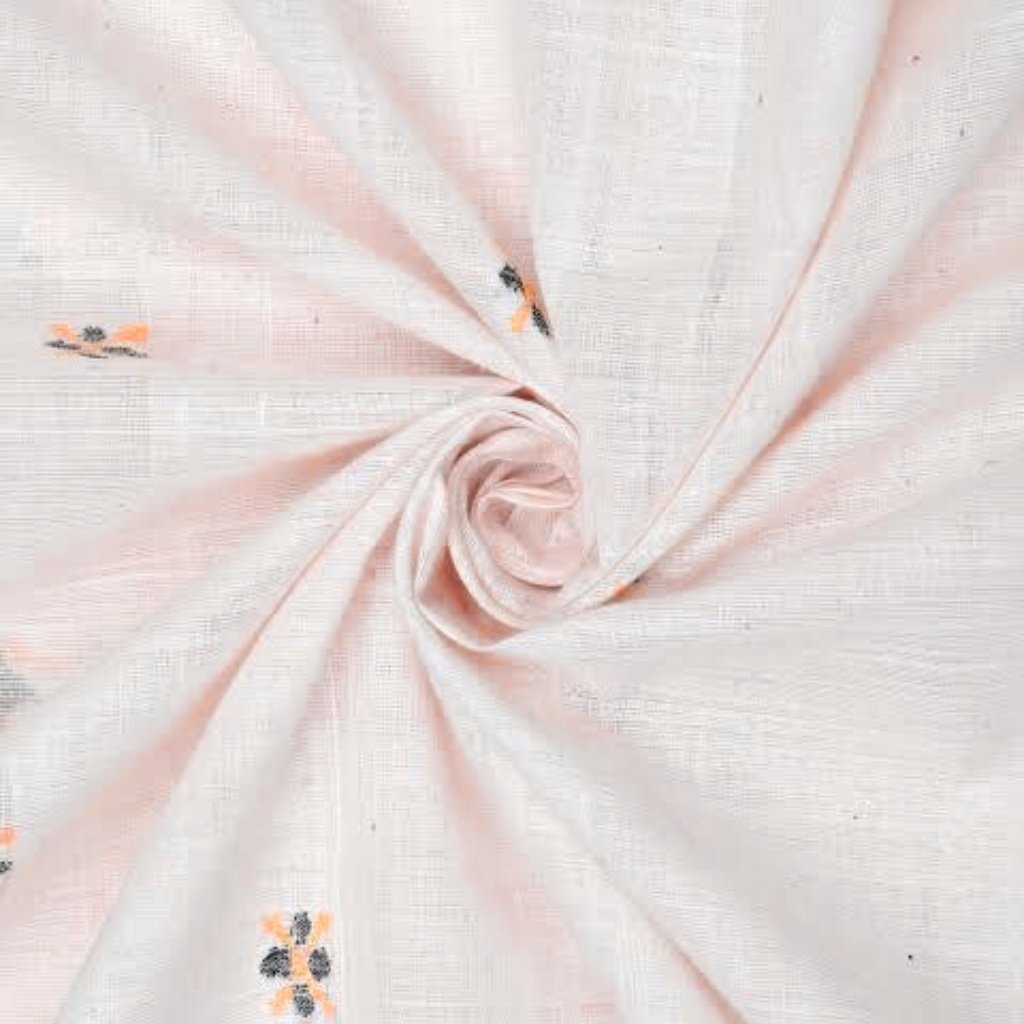 "Close-up view of soft pink khadi cotton fabric draped and twisted into a spiral, showing subtle texture and woven grid pattern with small floral-like motifs in orange and dark blue.