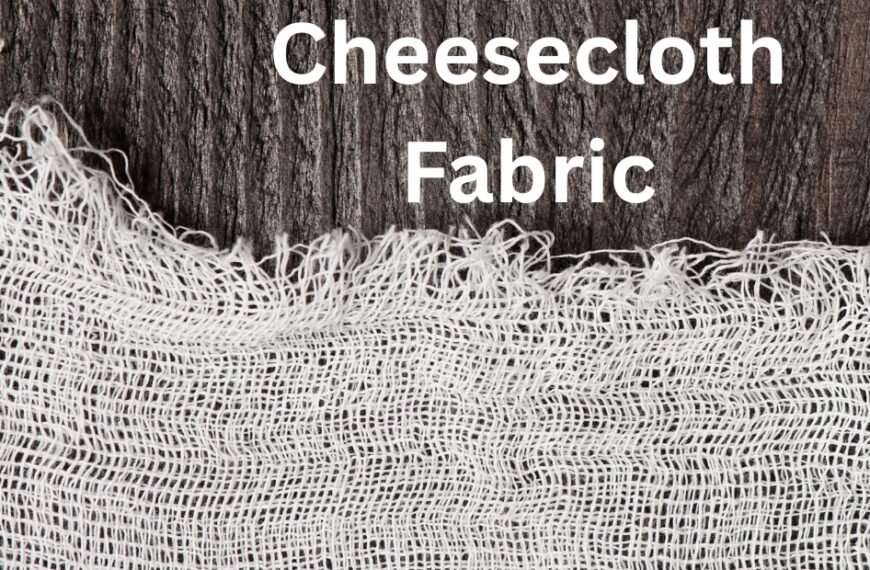 Close-up of a piece of cheesecloth fabric draped over a dark wooden background, showing its loose weave and frayed edges.