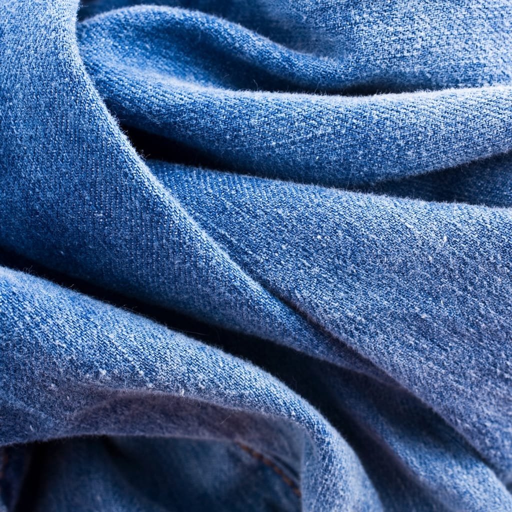  A close-up view of soft blue denim fabric with textured folds and creases.