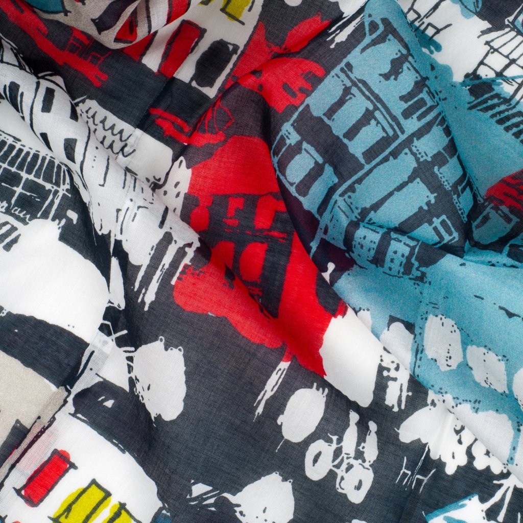 Close-up of colorful abstract-patterned fabric with red, blue, black, white, and yellow shapes and brushstroke designs.