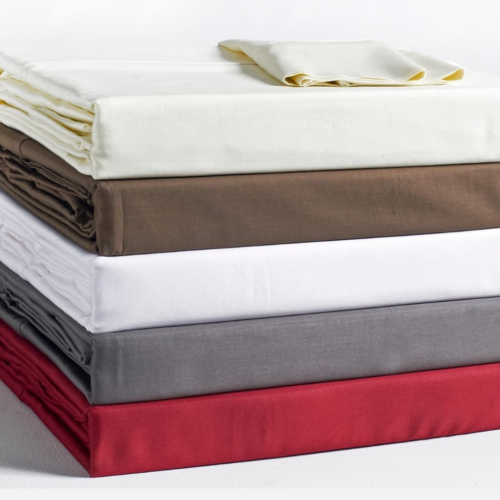 Stack of neatly folded Egyptian cotton sheets in varying colors (cream, brown, white, gray, red) with a soft, smooth texture that conveys exceptional softness.
