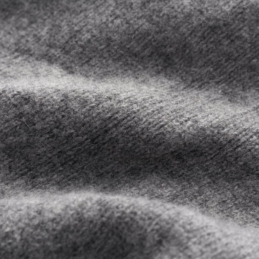 Close-up view of soft, heather gray wool fabric with a fuzzy, brushed texture and subtle folds, showing a cozy, woolen surface.