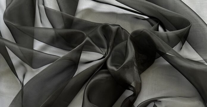 Soft, flowing black and gray sheer fabric draped and twisted