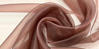 Brown Organza Fabric: Classic Beauty for Modern Fashion A soft, sheer brown fabric laid in swirling folds on a light background. Brown Organza Fabric