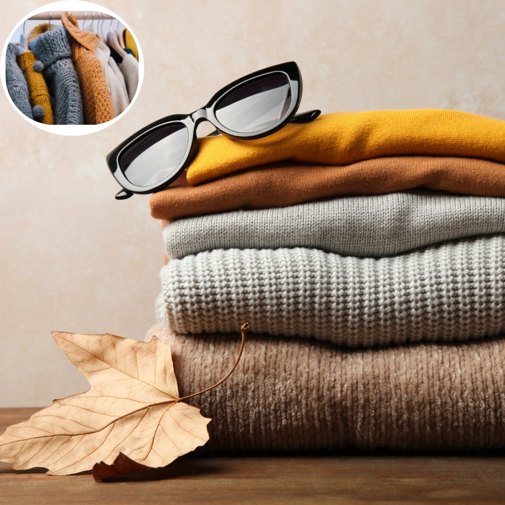 Sheep Wool Clothing: Natural Warmth and Timeless Style 15 Stack of folded knit sweaters in neutral tones with a pair of black sunglasses on top; a dried autumn leaf rests on the table in front; a circular inset shows clothing on hangers in the background.