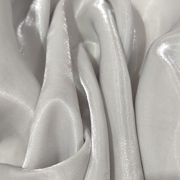 Close-up of lustrous metallic organza fabric with soft, flowing folds and a subtle sheen that reflects light. Metallic Organza Fabric