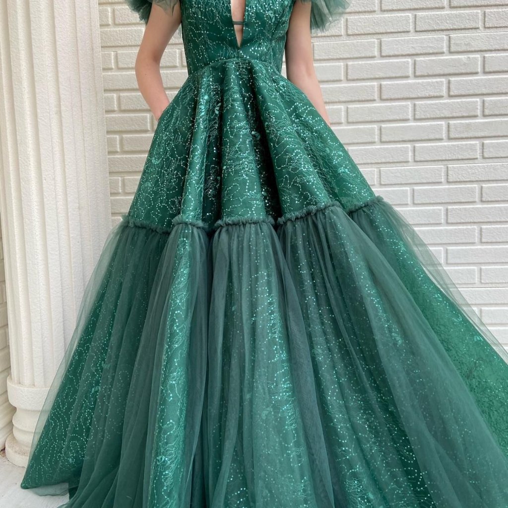 Green Organza Fabric: Elegant Choices for Fashion and Decor 22 A woman wearing a floor-length emerald green ball gown with a fitted bodice and a voluminous, two-tiered tulle skirt.