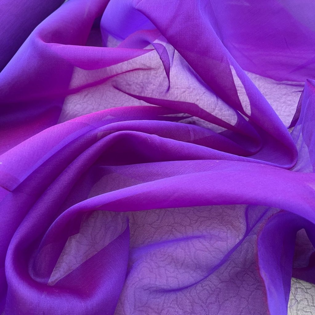 A close-up view of draped, sheer purple fabric gathered in soft folds.