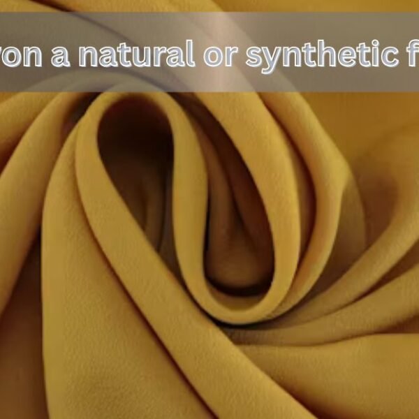 Close-up of soft yellow rayon fabric with text asking if rayon is a natural or synthetic fiber.