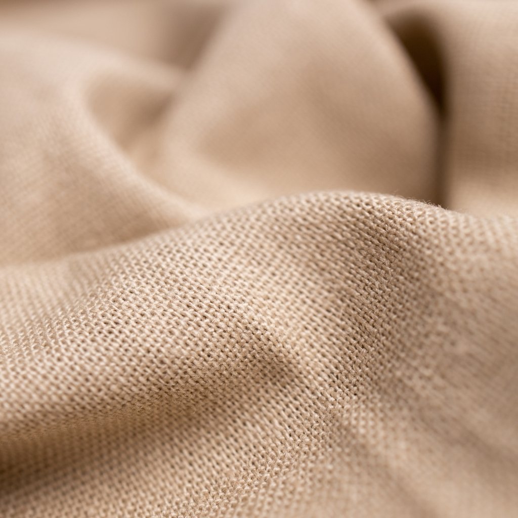 Close-up of beige linen fabric with visible weave and soft folds.