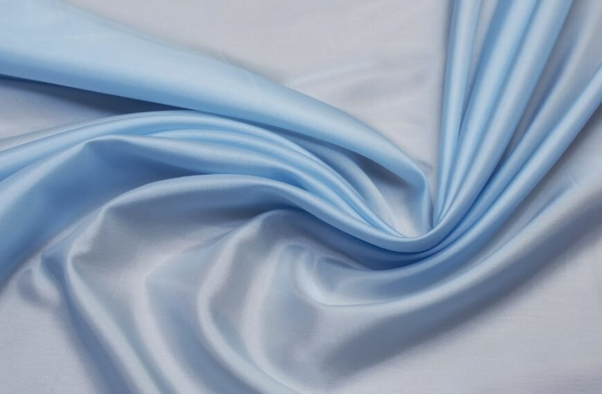 Soft, light blue linen-rayon fabric draped in gentle folds, showing a smooth, slightly glossy surface. Linen Rayon Fabric