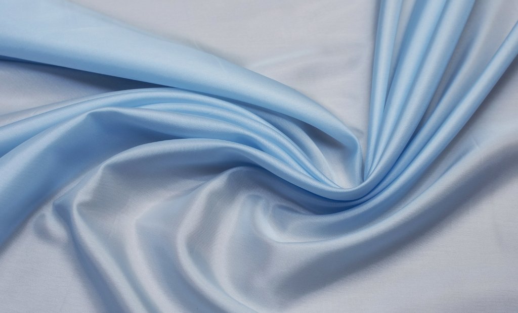 Soft, light blue linen-rayon fabric draped in gentle folds, showing a smooth, slightly glossy surface. Linen Rayon Fabric