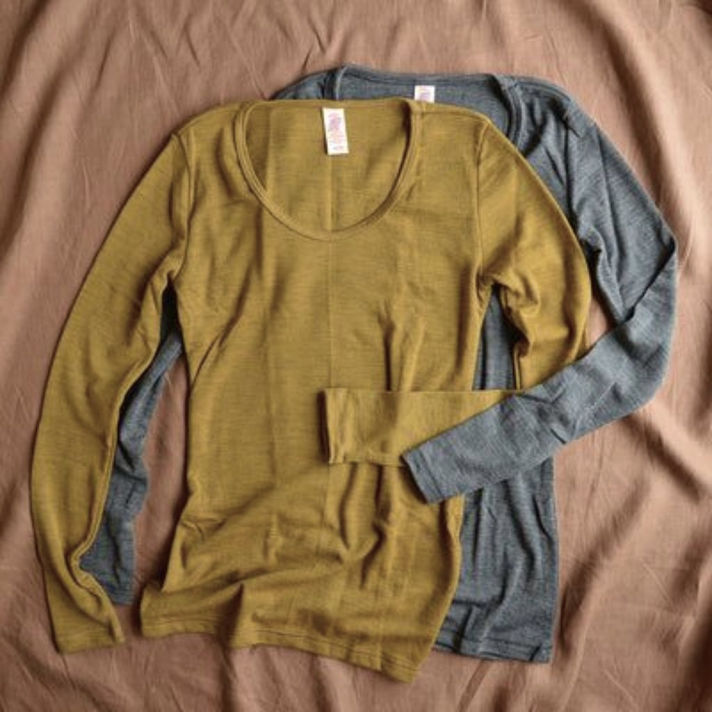 Two long-sleeve shirts layered on a beige surface; one mustard yellow in front, one muted blue-gray in back.