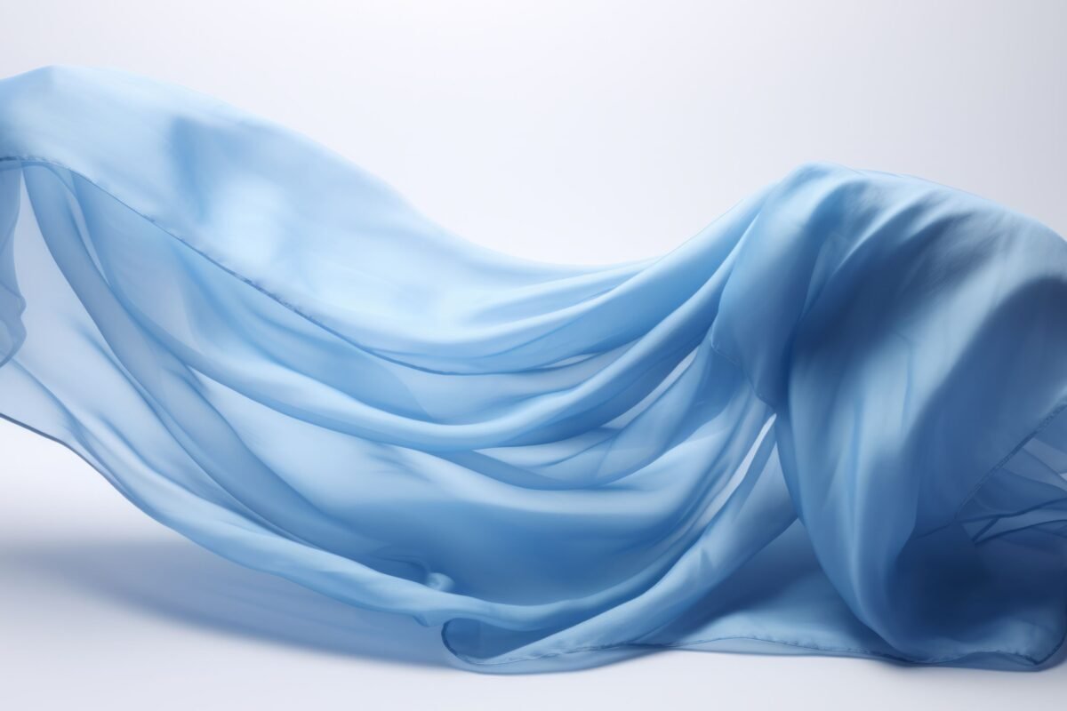 A light, airy piece of rayon chiffon fabric in soft sky-blue, intricately draped and flowing with gentle folds against a pale background.