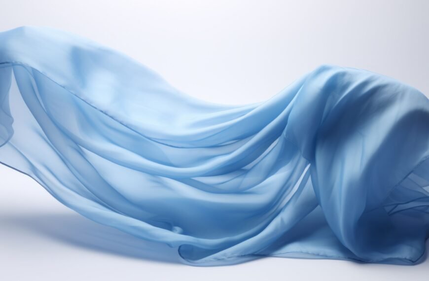A light, airy piece of rayon chiffon fabric in soft sky-blue, intricately draped and flowing with gentle folds against a pale background.