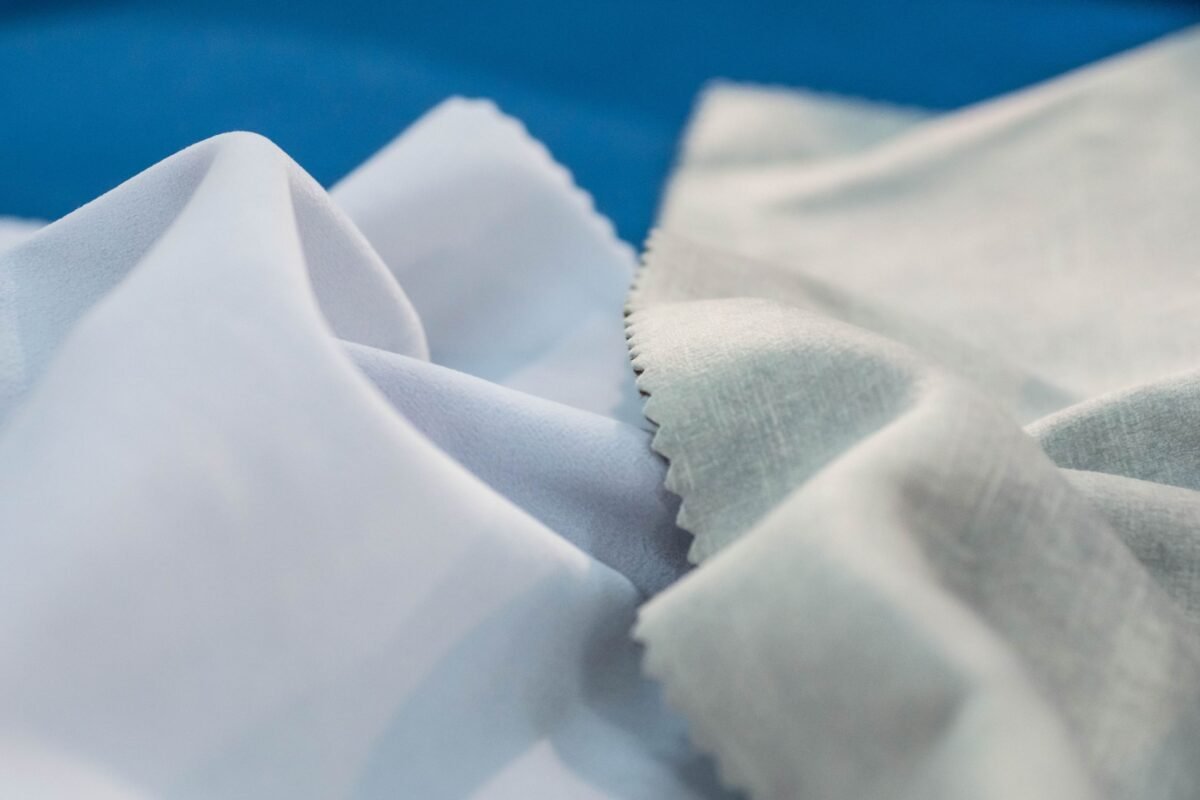 Close-up of delicate, softly folded Rayon shrink fabric with smooth, light fibers in white and pale gray tones