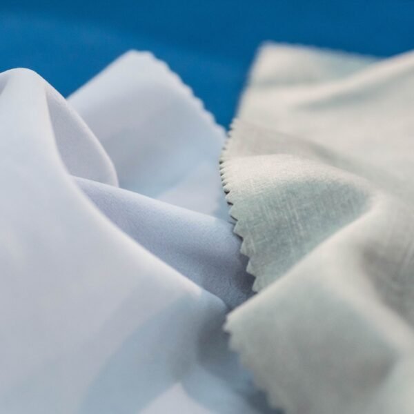 Close-up of delicate, softly folded Rayon shrink fabric with smooth, light fibers in white and pale gray tones