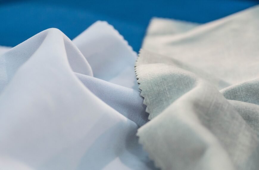Close-up of delicate, softly folded Rayon shrink fabric with smooth, light fibers in white and pale gray tones