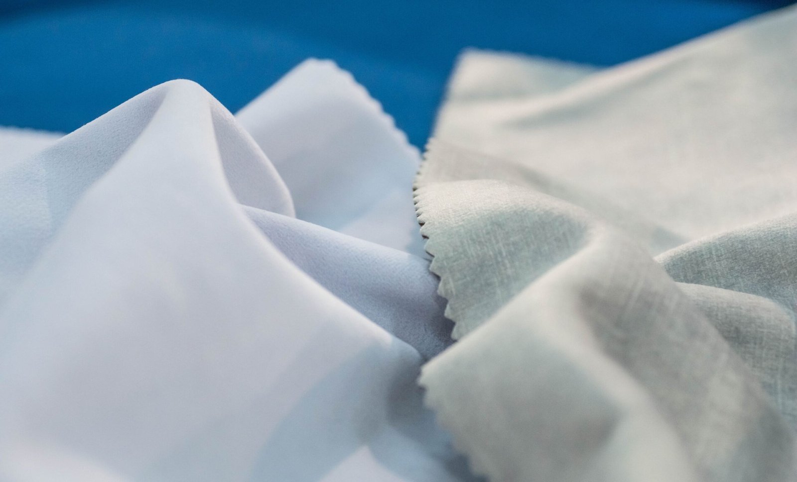 Close-up of delicate, softly folded Rayon shrink fabric with smooth, light fibers in white and pale gray tones