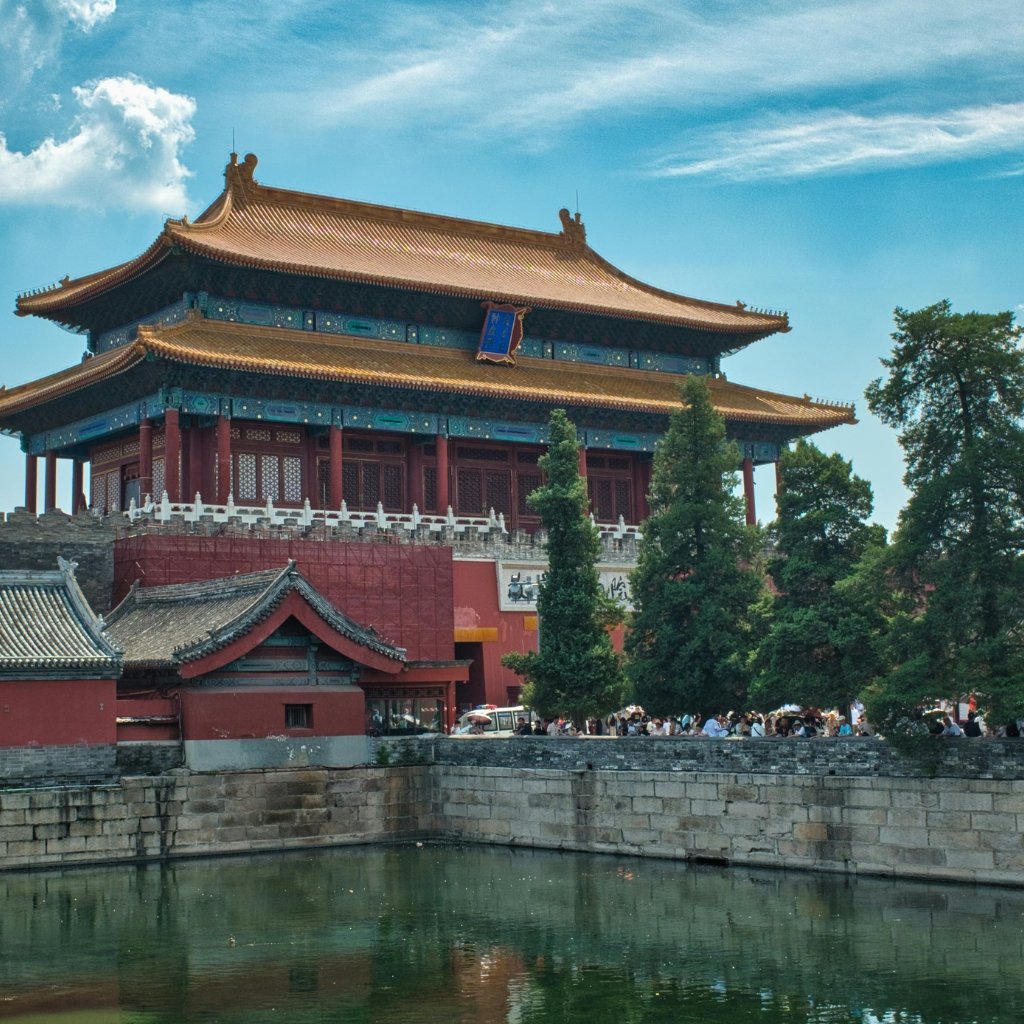 Black Organza Fabric: A Timeless Choice for Stylish Outfits 15 Traditional Chinese temple with ornate blue and gold roof, red walls, and a surrounding stone wall by a calm moat; trees and a blue sky in the background