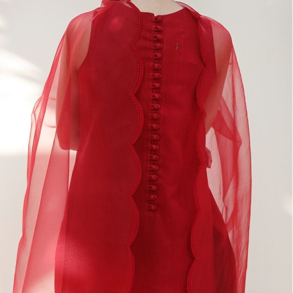 A bright red dress with sheer, puffed sleeves and a structured front. The back features a row of fabric-covered buttons and decorative scalloped edging along a curved seam.