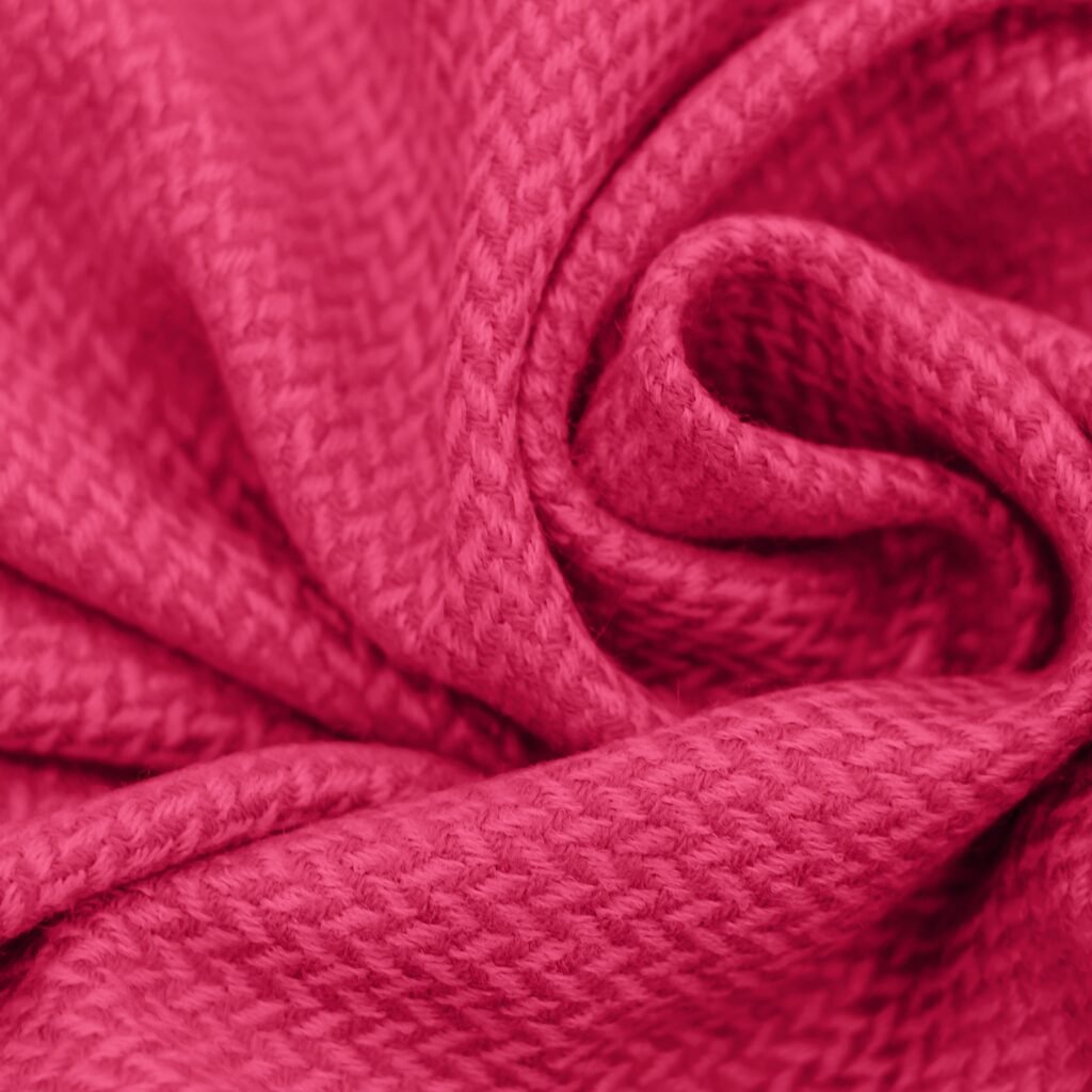 Close-up view of a vibrant pink rayon blend fabric with a soft, woven texture and gentle folds.