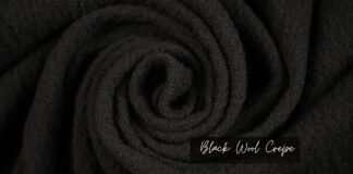 Black Wool Crepe: Full Guide to Elegant and Versatile Fabric A close-up view of soft, black wool crepe fabric, showing its smooth, velvety texture and rolled fibers.