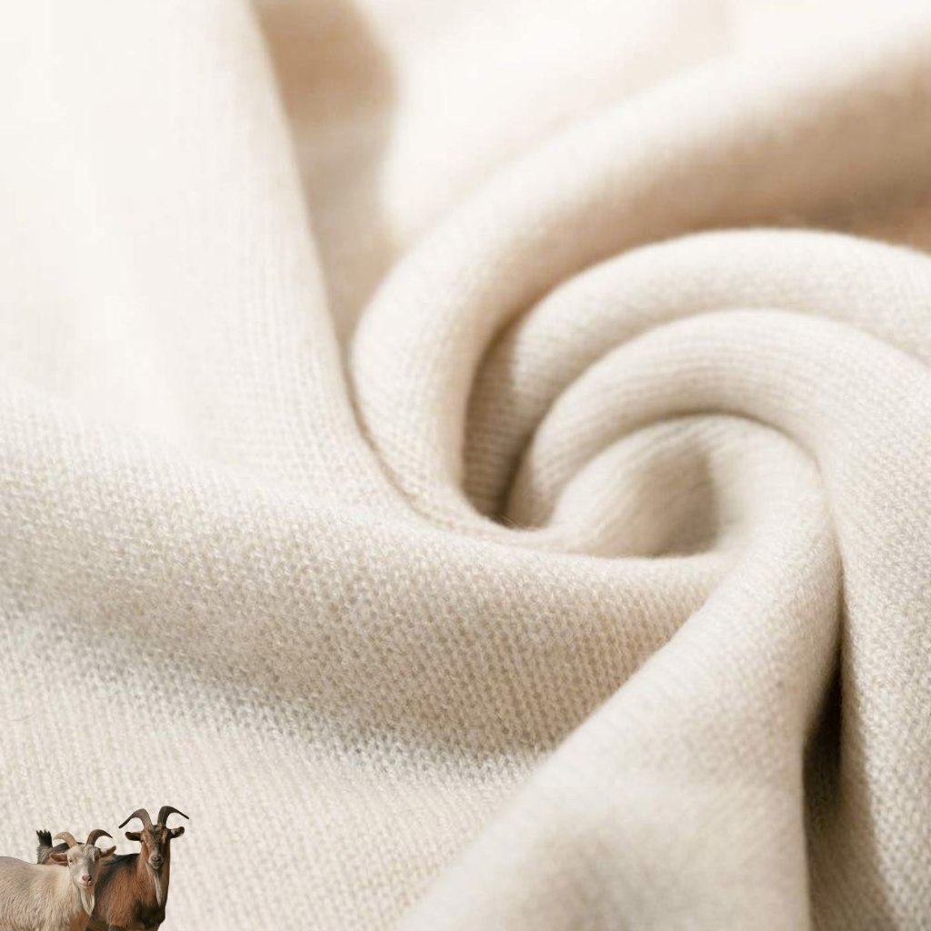 A soft, cream-colored fabric with a gentle swirl fold. In the bottom-left corner, three small goats stand together, appearing as tiny decorative figures against the textile.