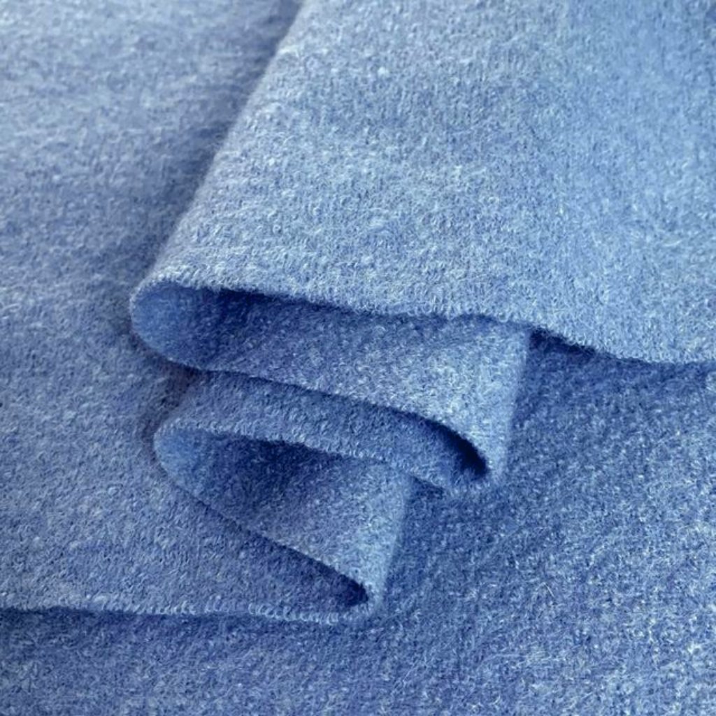 Close-up of soft, heathered blue fabric with rolled edges and layered folds.