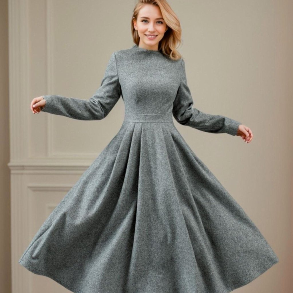 A woman wearing a long, gray, full-skirted dress with long sleeves spins gracefully, creating a circular motion with the pleated skirt.