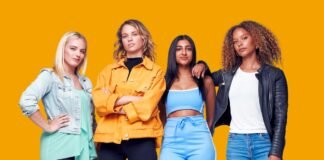 Designer Track Jacket: Your Ultimate Guide to Luxury Style. Four women standing against a solid orange background, posing confidently; they wear casual, colorful outfits including denim jackets, a bright orange utility jacket, a blue crop top with matching blue pants, and a black leather jacket. Designer Track Jacket