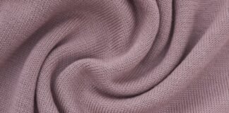 Felted Merino Fabric: Premium Softness for Cozy Elegance A close-up of soft, lavender-pink knit fabric with curved folds. Felted Merino Fabric
