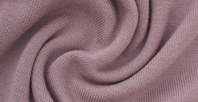 A close-up of soft, lavender-pink knit fabric with curved folds. Felted Merino Fabric
