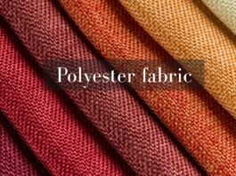 Flame Retardant Polyester The Guide to Fire-Resistant Fabric Close-up of folded polyester fabric in warm autumn shades, including burgundy, rust, and tan, with a soft textile texture visible. Flame Retardant Polyester