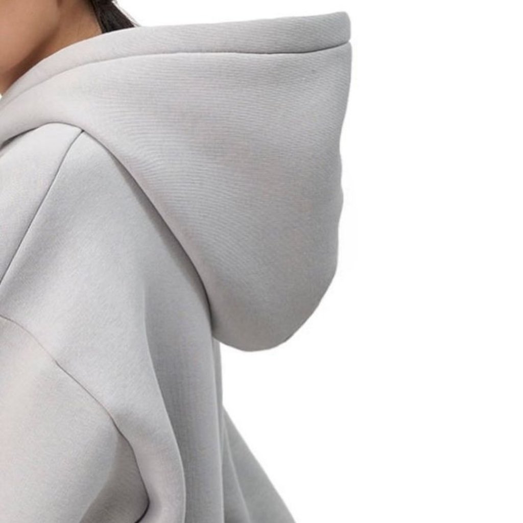 A close-up side view of a light gray hoodie with the hood up.