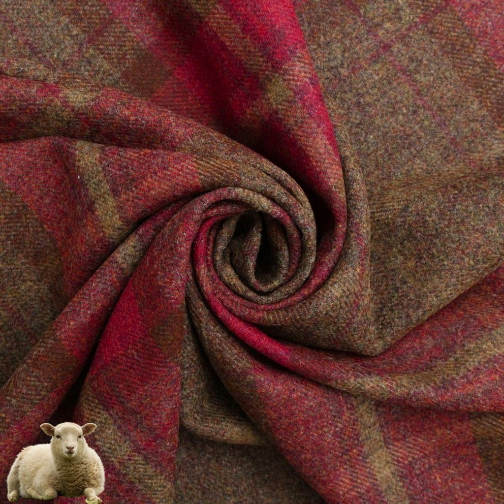 A close-up of red and brown plaid fabric gathered into a swirl, with a small white lamb on the bottom left corner.