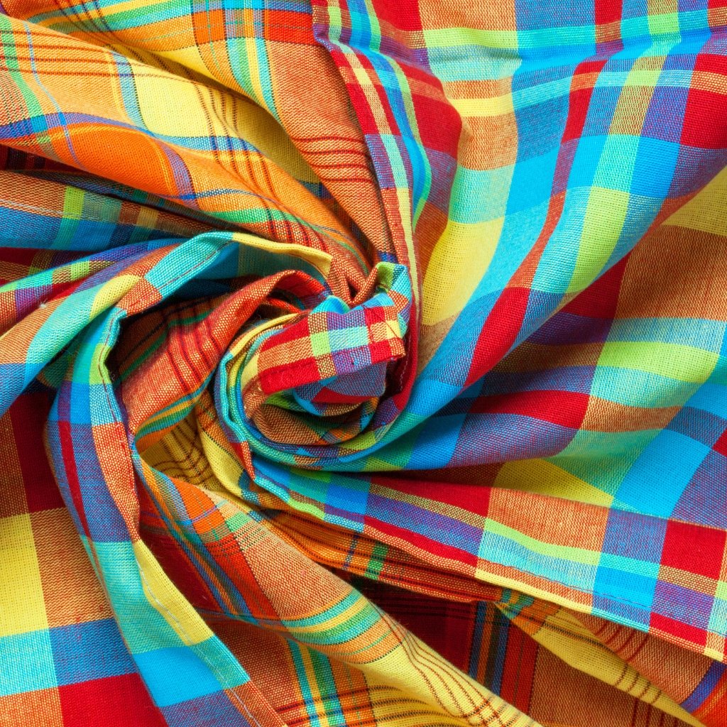  A close-up view of brightly colored plaid fabric, twisted into folds and a central knot, featuring red, orange, yellow, green, blue, and purple checks.
