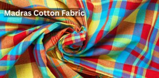 What Is Madras Cotton Fabric? Complete Guide for Beginners Close-up of colorful Madras cotton fabric with a plaid pattern, twisted into folds.