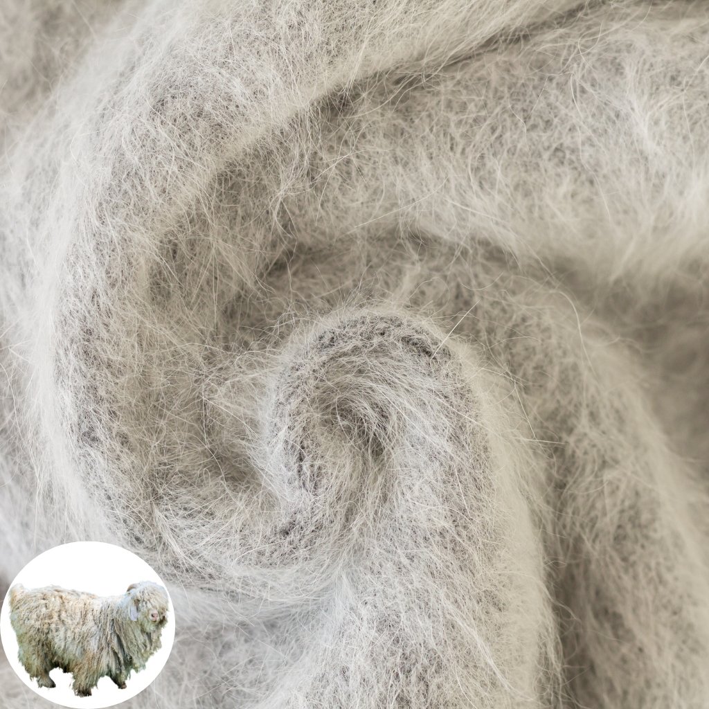 Close-up of light gray, fluffy wool fibers, showing tangled fleece with coarse, curly locks. A small circular inset image of a sheep is in the bottom-left corner.
