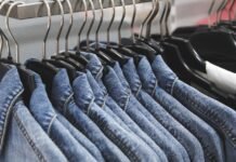 Overshirt Jacket: A Perfect Blend of Modern Style & Comfort A row of denim jackets hanging on black hangers along a clothing rack.