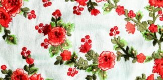 Printed Cotton Fabric: Stylish, Soft, and Versatile Designs Embroidered red flowers with green leaves on light blue fabric Printed Cotton Fabric