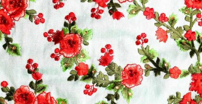 Embroidered red flowers with green leaves on light blue fabric Printed Cotton Fabric