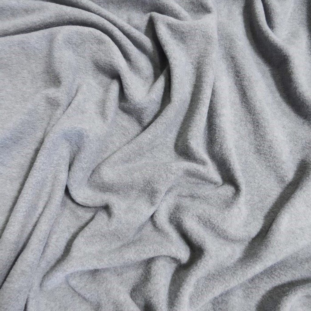 A close-up view of soft, light gray fabric with gentle folds and ripples, creating subtle shadows and texture.