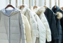 Top 20 Types of Overcoats Every Stylish Man Should Know A row of insulated winter jackets hanging on wooden hangers against a light background.