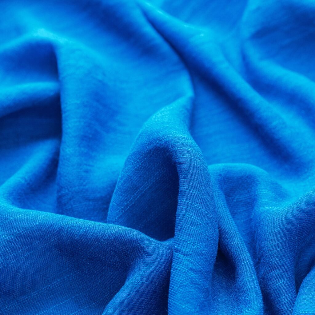 A close-up view of smooth, bright royal blue fabric with soft folds and a gentle sheen, showcasing a lightweight, drapable textile.Is rayon a good fabric