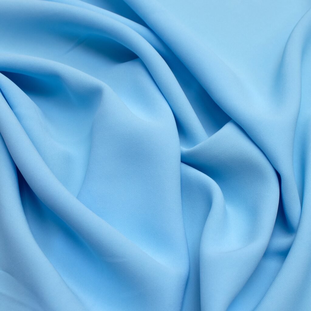 "Close-up of light blue Rayon fabric with soft folds and smooth texture."