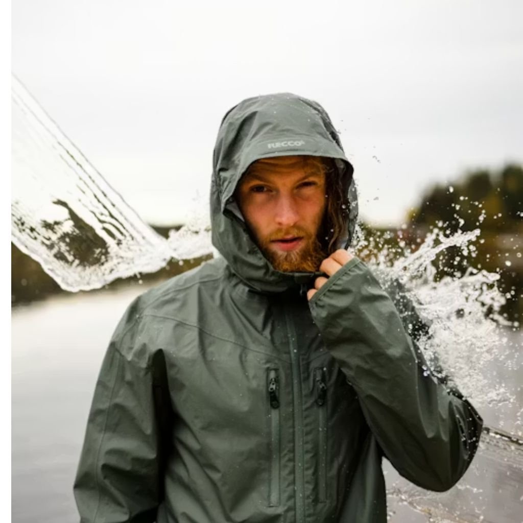 Waterproof or Water-Resistant Puffers: What You Should Know 16 A man wearing a color-blocked puffer jacket with a beige hood and shoulders, green body, and black sleeves, standing against a plain white background.Waterproof or Water-Resistant Puffers