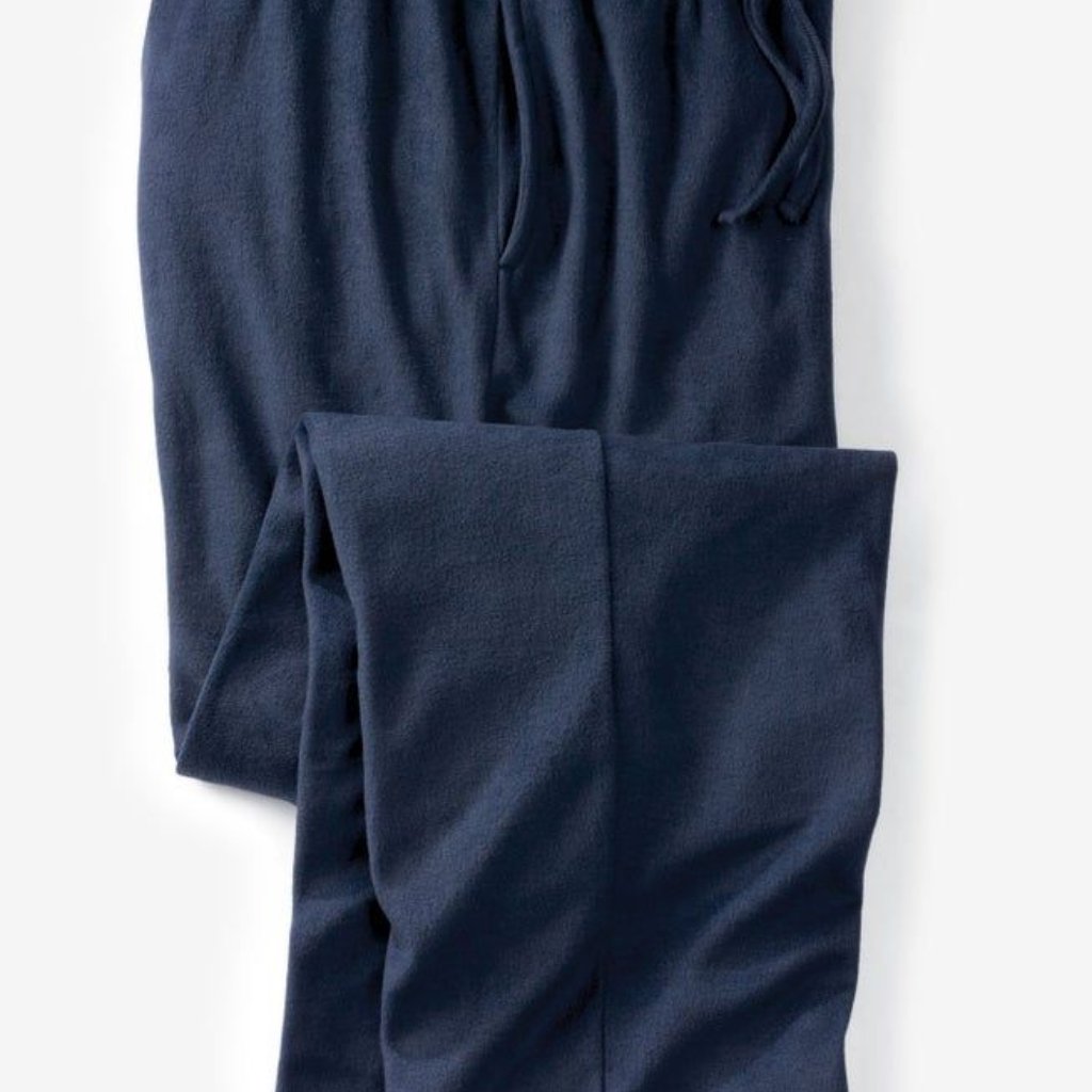 A close-up view of navy blue sweatpants with a folded leg, showing soft fleece material and a drawstring waist