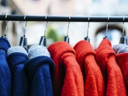 A stack of neatly folded knitted sweaters in gray, cream, and mustard colors showing various textured patterns.Types of Winter Fashion Trends