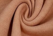 What Is Brushed Cotton Fabric? Benefits, Types & Best Uses A close-up view of a soft, tan-colored polyester fabric twisted into a swirl, often used to illustrate questions like does polyester make you sweat due to its texture and weave.what is brushed cotton fabricwhat is brushed cotton fabric